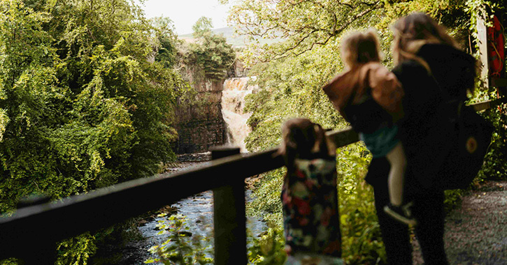 Mother and two children enjoying the view of High Force Waterfall